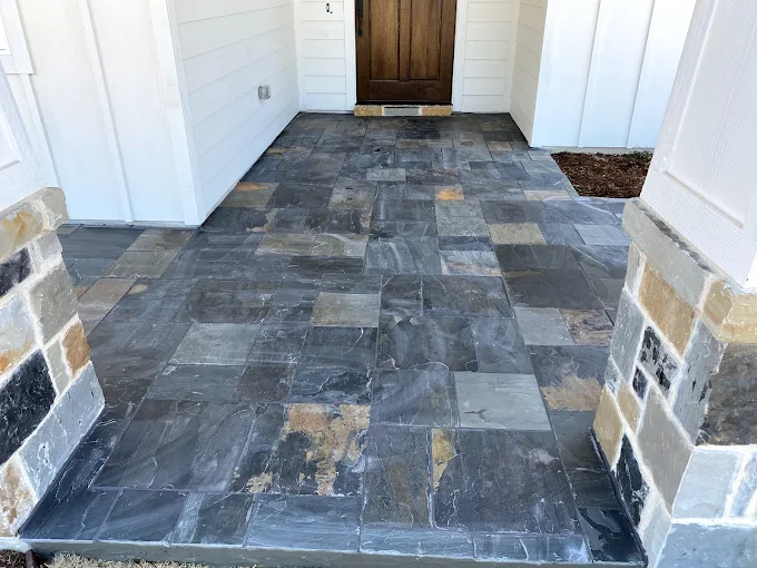 Custom stone porch flooring installed on a Texas home
