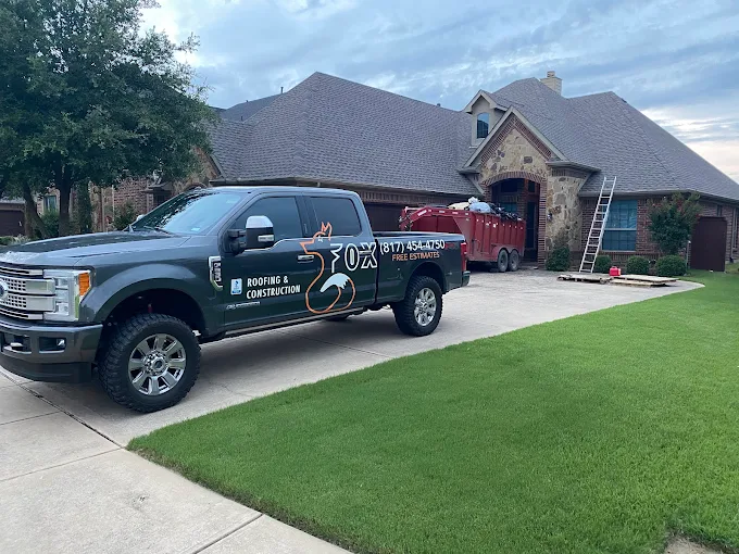 Fox Roofing truck and dumpster on-site at a Texas stone-and-brick home tear-off